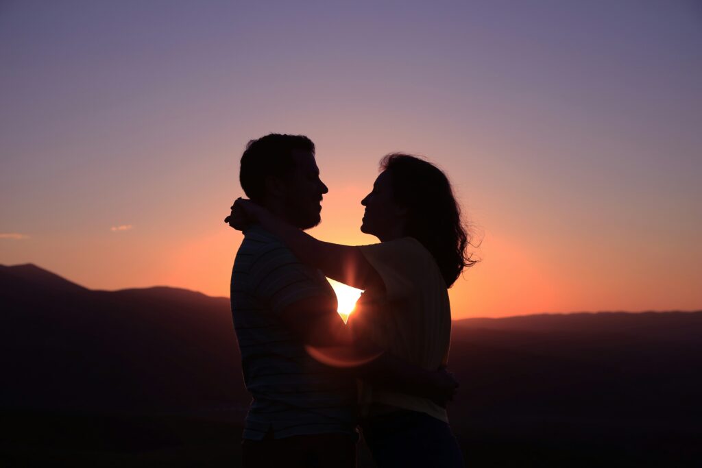 見つめ合う男女夕日の写真